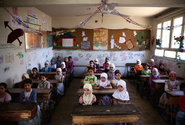 Syrian school girls sit at their classroom at the Saif al-Dawla school as they take part in activities surrounding an art competition organized as part of a local initiative to shift the children's minds from the atrocities of the Syrian war, on May 25, 2016, in Douma.Abd Doumany / AFP