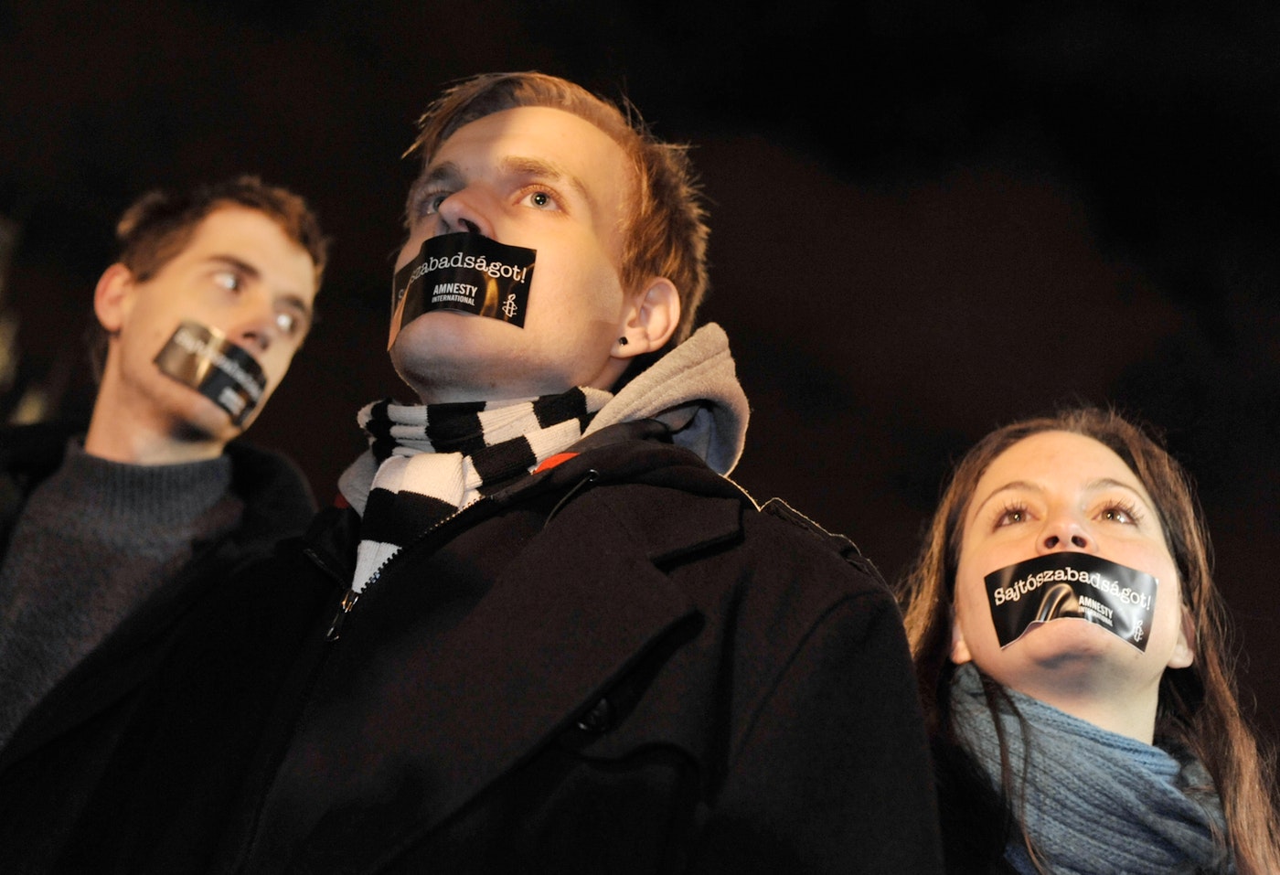Hungarian Amnesty International activists protest with taped mouth during a demonstration against the government’s new media law in Budapest in 2011. The message, in Hungarian, reads “We want press freedom!” (AP/Bela Szandelszky)