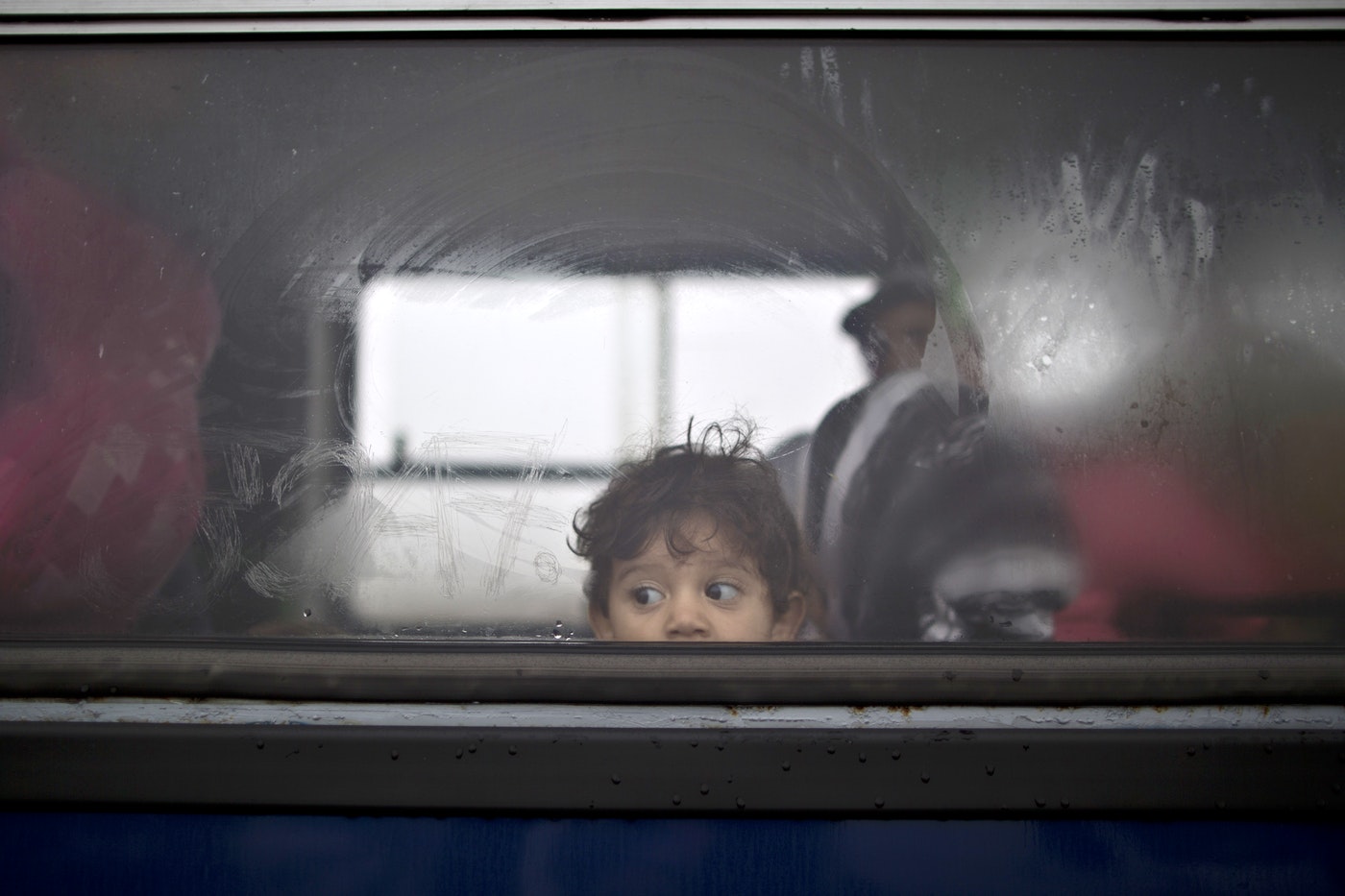 A Syrian refugee child looks out of a bus that will take him and his family to the center for asylum seekers in southern Hungary. (AP/Muhammed Muheisen)