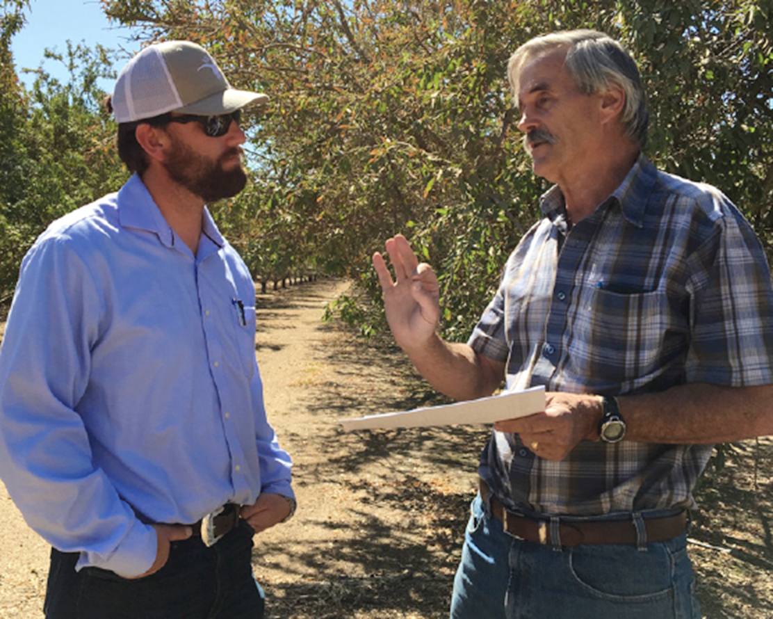 Spencer Cooper, left, senior manager of irrigation and water efficiency at the Almond Board of California, discusses drip system performance and irrigation system maintenance with Kern County farm adviser Blake Sanden. (Photo Courtesy Almond Board of California)