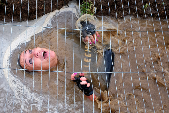 A participant crawls under a fence the Legion Run, a 5-kilometer team-oriented run with obstacles of mud, fire, ice and barbed wire, in Rome on November 5, 2016.  / AFP / ALBERTO PIZZOLI        (Photo credit should read ALBERTO PIZZOLI/AFP/Getty Images)