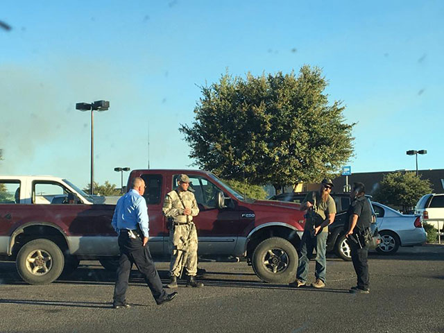 Nogales Police Department officers greet members of the III% United Patriots militia at the Nogales Walmart parking lot in March 2017. (Photo: Arielle Zionts)
