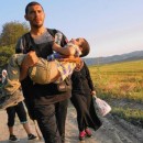 Mohammed Rantisi, a Syrian-born Palestinian, carries his son Adam toward the Macedonian border. Mohammed and his family are headed to Denmark, where his ailing mother lives. (Photo: Liliana Nieto del Rio / For The Times)