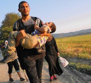 Mohammed Rantisi, a Syrian-born Palestinian, carries his son Adam toward the Macedonian border. Mohammed and his family are headed to Denmark, where his ailing mother lives. (Photo: Liliana Nieto del Rio / For The Times)