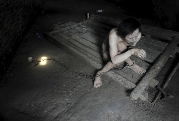 Tong Jieping, 44-year-old mentally disabled patient, is chained by his foot inside his room, in Qunxing village of Wangjiang county, Anhui province, China, July 14, 2015. Tong was diagnosed mentally ill when he was in his 20s. His parents, both in their 70s, could not afford the medical treatments so they had to lock him up in chains to prevent him from running away, according to Tong's family. REUTERS/Stringer CHINA OUT. NO COMMERCIAL OR EDITORIAL SALES IN CHINA         TPX IMAGES OF THE DAY      - RTX1KA0W
