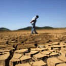 A worker of SABESP, a Brazilian enterprise of Sao Paulo state, that provides water and sewage services to residential, commercial and industrial areas looks at the cracked ground of Jaguary dam in Braganca Paulista, 100 km from Sao Paulo January 31, 2014. This has been the hottest January on record in parts of Brazil, and the heat plus a severe drought has fanned fears of water shortages, crop damage, and higher electricity bills that could drag down the economy during an election year for President Dilma Rousseff.  REUTERS/Nacho Doce (BRAZIL - Tags: ENVIRONMENT ENERGY POLITICS TPX IMAGES OF THE DAY) - RTX182N6