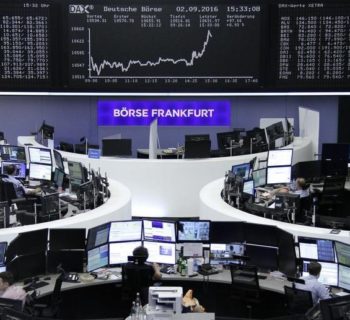 Traders work at their desks in front of the German share price index, DAX board, at the stock exchange in Frankfurt, Germany, September 2, 2016. REUTERS/Staff/Remote