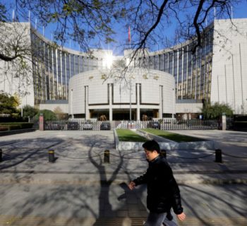 A man walks past the headquarters of the People's Bank of China (PBOC), the central bank, in Beijing November 20, 2013.  REUTERS/Jason Lee/File Photo