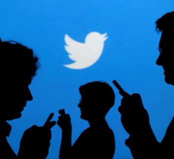 People holding mobile phones are silhouetted against a backdrop projected with the Twitter logo in this illustration picture taken in  Warsaw September 27, 2013.   REUTERS/Kacper Pempel/Illustration/File Photo