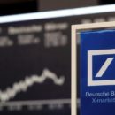 A Deutsche Bank banner is pictured in front of the German share price index, DAX board, at the stock exchange in Frankfurt, Germany September 30, 2016. REUTERS/Kai Pfaffenbach/File Photo
