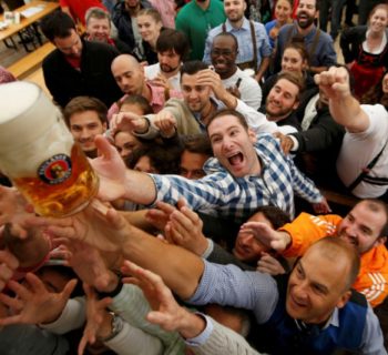 Visitors reach for the one of the first mugs of beer during the opening day of the 183rd Oktoberfest in Munich, Germany, September 17, 2016. REUTERS/Michaela Rehle/File Photo