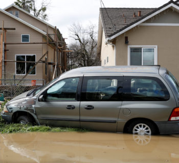 A car is see partially submerged in water after Coyote Creek burst its banks and flooded nearby neighborhoods and prompted evacuation of more than 14,000 residents in San Jose, California, U.S., February 22, 2017. REUTERS/Stephen Lam
