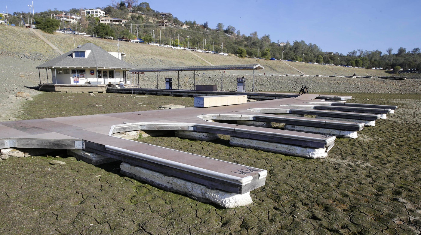 In this Nov. 17, 2014 file photo, boat slips sit on the dry lake bed at Brown's Marina at Folsom Lake, near Folsom Calif. Global warming worsened record droughts in California. (Rich Pedroncelli, AP)