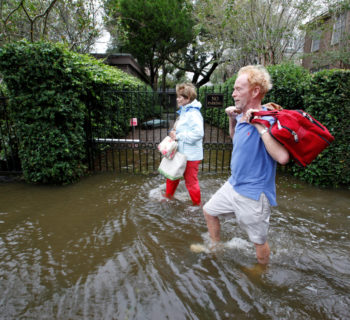 Residents of an upscale historic neighborhood wade through flood waters as they return to their home after Hurricane Matthew hit Charleston, South Carolina. REUTERS/Jonathan Drake