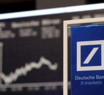 A Deutsche Bank banner is pictured in front of the German share price index, DAX board, at the stock exchange in Frankfurt, Germany September 30, 2016. REUTERS/Kai Pfaffenbach/File Photo