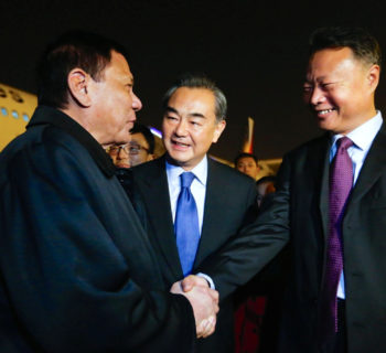 President of the Philippines Rodrigo Duterte (L) shakes hands with Chinese ambassador to the Philippines Zhao Jianhua (R), as Chinese Foreign Minister Wang Yi (C) looks on, at airport in Beijing, China, October 18, 2016. CNS Photo via REUTERS