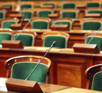 Empty vintage congress hall with seats and microphones.