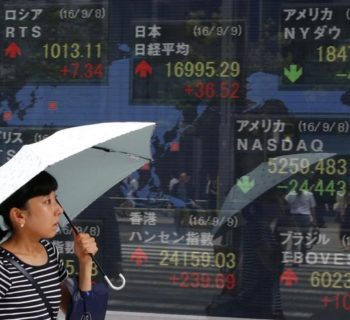 A woman walks past stock quotation board outside a brokerage in Tokyo, Japan, September 9, 2016.   REUTERS/Kim Kyung-Hoon