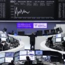 Traders work at their desks in front of the German share price index, DAX board, at the stock exchange in Frankfurt, Germany, October 12, 2016. REUTERS/Staff/Remote
