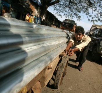 Workers push a cart laden with steel pipes in Mumbai January 12, 2009. REUTERS/Punit Paranjpe
