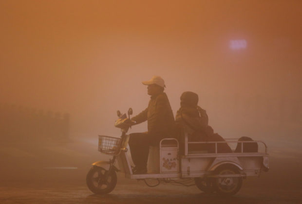 People ride during heavy smog in Lianyungang, Jiangsu province, China, November 13, 2016. REUTERS/Stringer