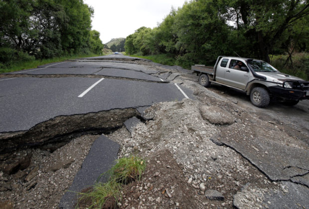 A four-wheel-drive vehicle negotiates the damaged State Highway One near the town of Ward, south of Blenheim, South Island. REUTERS/Anthony Phelps