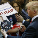 FILE - In this May 6, 2016 file photo, Republican presidential candidate Donald Trump looks at his photo on a magazine cover as he signs autographs during a rally in Eugene, Ore. The city of Eugene plans to bill the Donald Trump campaign nearly $100,000 to pay for costs associated with last month's visit. Police Chief Pete Kerns said in an email Wednesday, June 22, 2016, that overtime compensation for police officers totaled $78,000 while firefighters and other city employees racked up another $10,000 in OT. (AP Photo/Ted S. Warren, file)