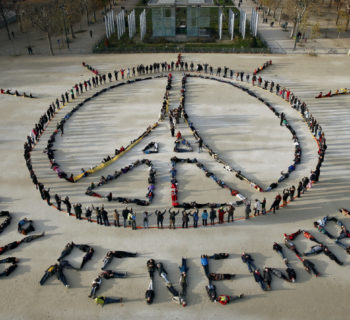 Hundreds of environmentalists arrange their bodies to form a message of hope and peace in front of the Eiffel Tower in Paris, France, December 6, 2015, as the World Climate Change Conference 2015 (COP21) continues at Le Bourget near the French capital. REUTERS/Benoit Tessier - RTX1XF6Y